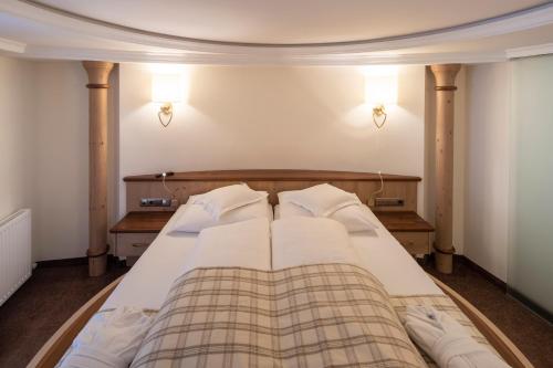 a large bed in a room with two lamps at Superior Hotel Post Ischgl in Ischgl