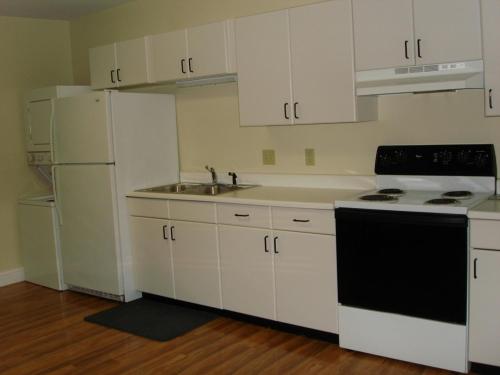 a kitchen with white cabinets and white appliances at Copley LaReine Motel in Old Orchard Beach