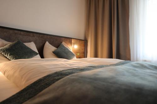 a bedroom with a bed with pillows and a window at Carpe Solem Rauris by ALPS RESORTS in Rauris