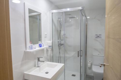 a bathroom with a shower, sink, and toilet at Hotel Roquiño in Caldas de Reis