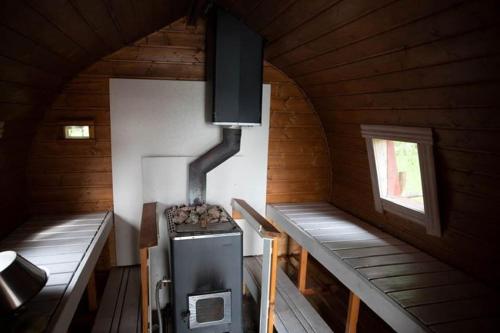 a room with a stove in a wooden cabin at Laawu Kultainkoski in Kotka