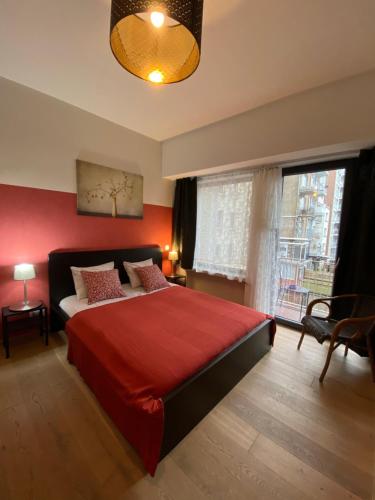 ein Schlafzimmer mit einem roten Bett und einem Fenster in der Unterkunft Brial apartment 2 bedrooms, in Antwerpen