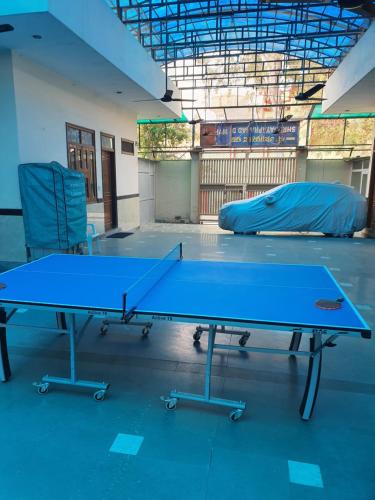 a ping pong table and two chairs in a room at Shri Gaya Prasad Dham in Vrindāvan