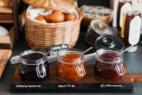 two jars of jam on a table with a basket of eggs at Hotel Esplanade in Gmunden