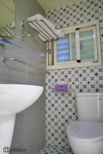 a bathroom with a toilet and a sink and a mirror at Mei Nong Villa in Meinong
