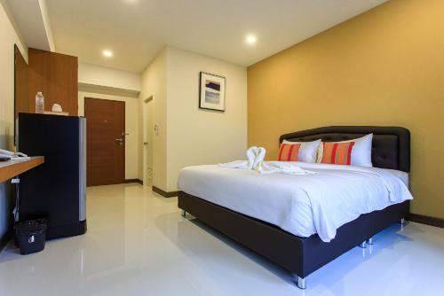 una camera da letto con un letto grande con lenzuola bianche di Chanapat Hotel a Chiang Mai