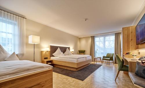 a hotel room with two beds and a desk at Hotel Weis in Mertesdorf
