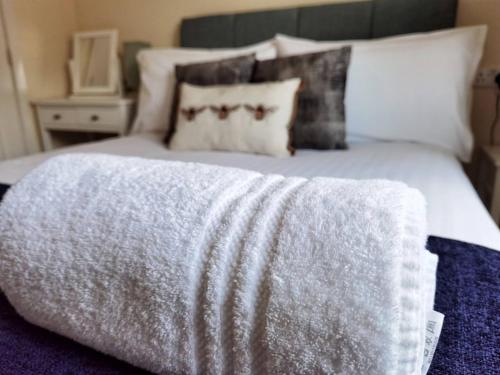 uma cama com um cobertor cinzento em cima em Lakeside: Argosy 3bed house 2bath parking M27 J5 Southampton Airport sleeps 6 em Southampton