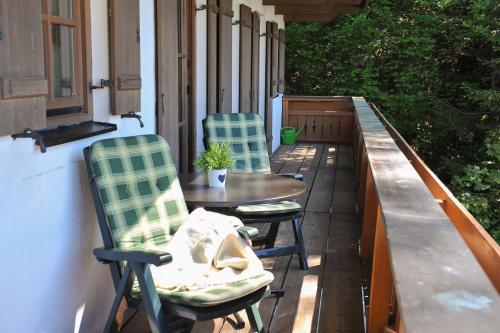 two chairs and a table on a porch at Am Sonnenhang inkl. Chiemgaukarte in Ruhpolding