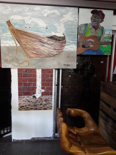 a painting of a man playing a guitar and a chair at Art Guest House in Lutzville