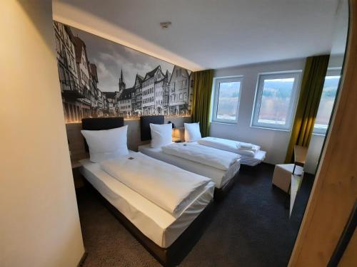 韋特海姆的住宿－Euro Hotel Wertheim，酒店客房设有两张床,墙上挂有绘画作品