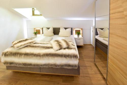 a bedroom with a large bed with a fur blanket at Am Sonnenhang inkl. Chiemgaukarte in Ruhpolding