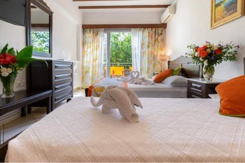 a stuffed elephant on a bed in a bedroom at Afrodite Hotel Apartments in Myrina