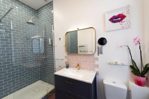 a bathroom with a sink and a shower with a mirror at Domaine Les Tilleuls in Wailly-Beaucamp