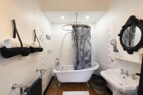 a white bathroom with a tub and a sink at Domaine Les Tilleuls in Wailly-Beaucamp