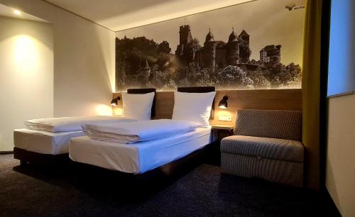 ein Hotelzimmer mit 2 Betten und einem Stuhl in der Unterkunft Euro Hotel Wertheim in Wertheim