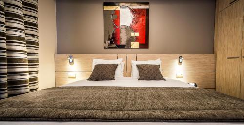 um quarto com uma cama e uma pintura na parede em Ibis Styles Charleroi Airport Aero 44 em Charleroi