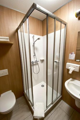 a bathroom with a shower and a toilet and a sink at Landhotel Gasthof Bauböck in Andorf