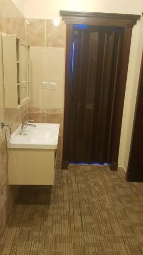 a bathroom with a sink and a black shower at Arabian Palm Hotel in Rabigh