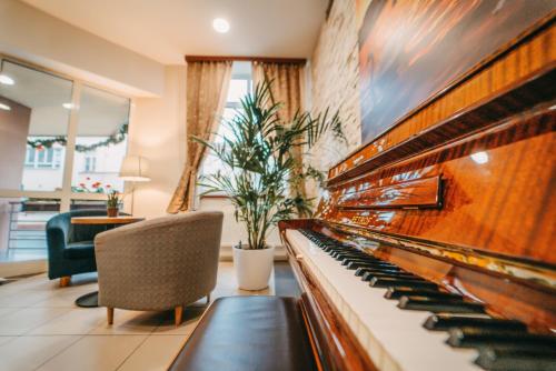a living room filled with furniture and a piano at Wellness Hotel Extol Inn - Czech Leading Hotels in Prague