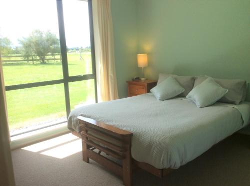 - une chambre avec un lit et une grande fenêtre dans l'établissement Oxford Holiday Cottage, à Oxford