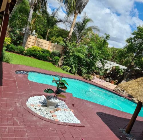 a pool with a pool table and a fountain at Ethen Guesthouse in Polokwane