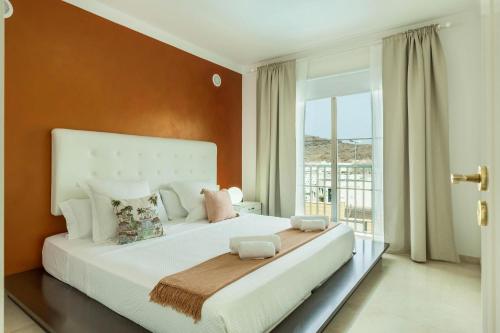sypialnia z dużym białym łóżkiem i oknem w obiekcie Villa Happy Dreamer w mieście Puerto Rico de Gran Canaria