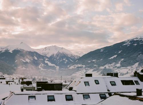 a town with snow covered mountains in the background at Hotel Blü Gastein in Bad Hofgastein