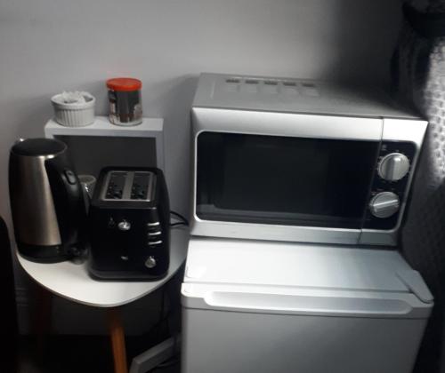 a microwave oven sitting on top of a refrigerator at Ideal one bedroom appartment in Naas Oo Kildare in Naas