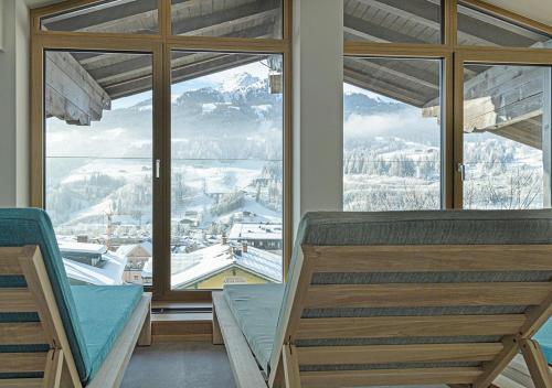 a room with a view of a snowy mountain through windows at Hotel Blü Gastein in Bad Hofgastein