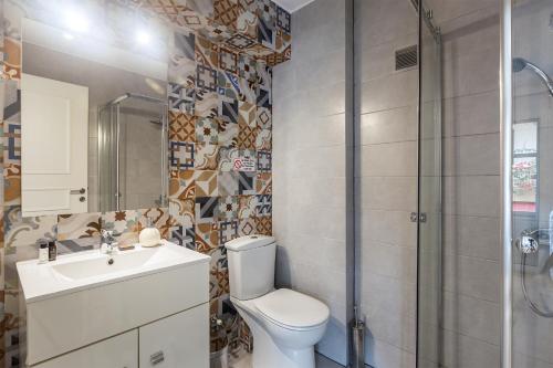 Un baño con inodoro, lavabo y ducha. en UrbanStay, en Atenas