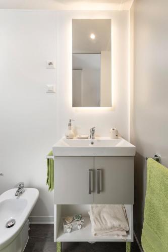 a white bathroom with a sink and a mirror at Camping Europa in Capoliveri
