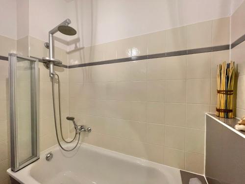 a bathroom with a shower and a tub at Premium CityApartment *Tiefgarage,Netflix,Zentrum* in Cottbus