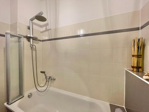 a bathroom with a shower and a tub at Premium CityApartment *Tiefgarage,Netflix,Zentrum* in Cottbus