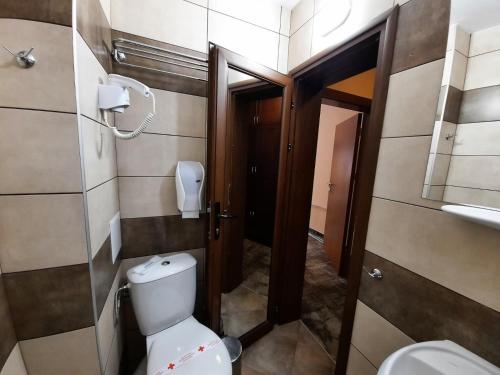 a small bathroom with a toilet and a door at Balkan Hotel in Chiflik