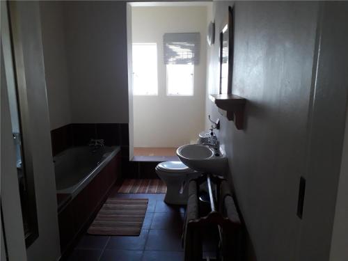 a bathroom with a sink and a toilet and a tub at Geduld in Prince Albert