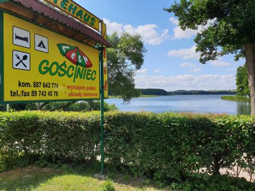 um sinal para um posto de gasolina com vista para um lago em Gościniec LECH em Kosewo