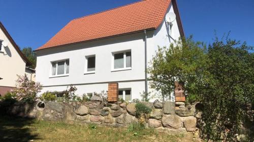 uma casa branca com um telhado vermelho e uma parede de pedra em Sellina em Ostseebad Sellin