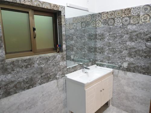 a bathroom with a sink and a mirror at Alpha Guest House in Rawalpindi