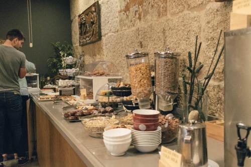 un hombre parado en una cocina con un buffet de comida en Peregrina Hotel, en Sanxenxo