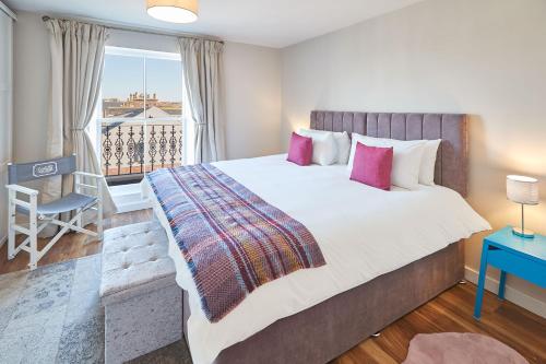 a bedroom with a large bed and a balcony at Host & Stay - Abbey Court Apartment in Whitby