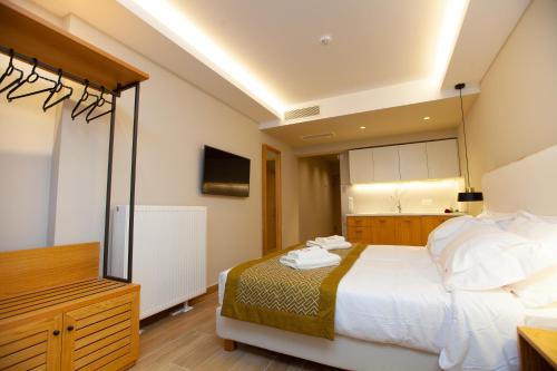 a bedroom with a large white bed and a television at No21 Luxury Suites in Thessaloniki