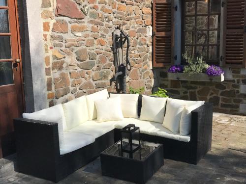 a black and white couch sitting in front of a building at Le Chénia in Wanze