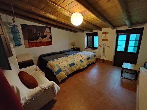 a bedroom with two beds and a couch at Casa Rural El Trepador Azul in Cabeza la Vaca