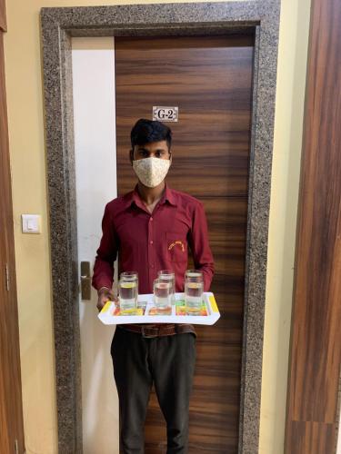a man in a mask holding a tray of drinks at Hotel Royal Suites in Ajmer