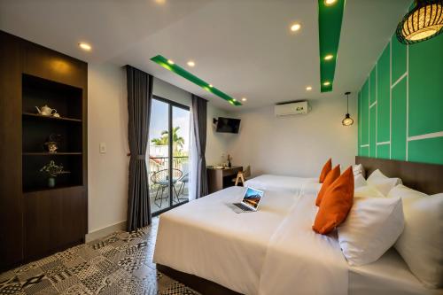 a bedroom with a bed with a laptop on it at AnNam68 in Hoi An