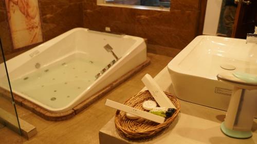 a bathroom with a bath tub next to a basket at Hotel Saheb's Castle McLeodganj in McLeod Ganj