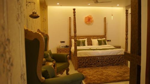 een slaapkamer met een bed en 2 stoelen bij Hotel Saheb's Castle McLeodganj in McLeod Ganj