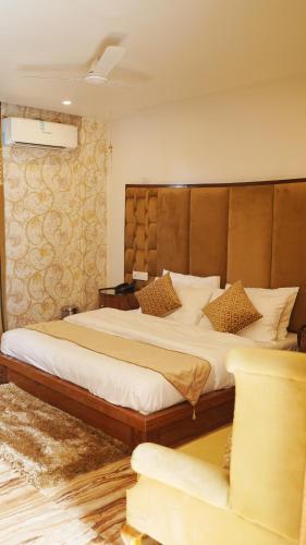 a bedroom with a large bed with a wooden headboard at Hotel Saheb's Castle McLeodganj in McLeod Ganj
