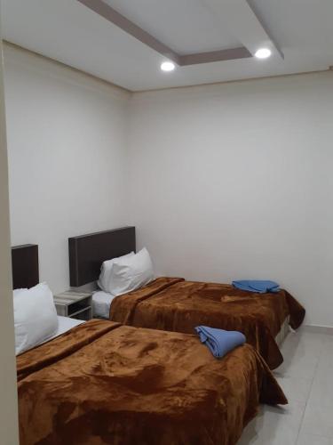 ein Hotelzimmer mit 2 Betten und braunen Decken in der Unterkunft SARAYA AWAD HEGAZI STREET- families only in Alexandria